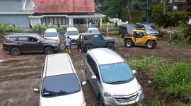 Slippery slope: Tourists' cars struggle in Bukittinggi-Indonesia parking lot after rain