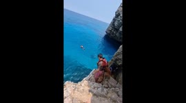 Cliff jumping adventure: man and his dogs brave the heights!