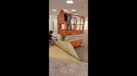 Ingenious solution: Man uses scissor lift to expedite carpet removal