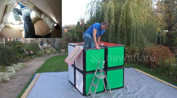 Puzzle mastermind solves Rubik's Cube inside giant replica