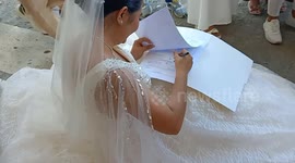 Workaholic bride signs school documents during her wedding ceremony