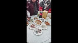 Family shares hot meal outside home as snow falls