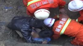 Firefighters dig through clay with bare hands to rescue trapped workers