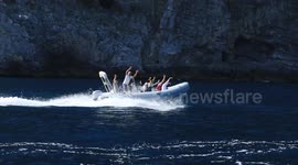 Speedboat passing by with happy people waving