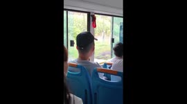 Baseball cap appears to levitate above bus passenger's head