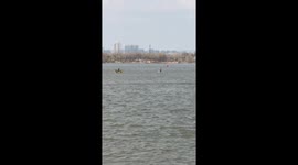 Man appears to walk on water while he walks across shallow river