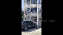 Heroic delivery rider scales building to douse first-floor fire in China
