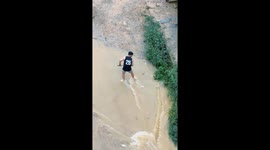 Man turns flooded streets into fishing grounds after torrential rainstorm in southern China