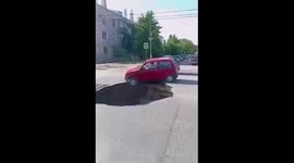 Careless driver nearly plunges car into massive hole