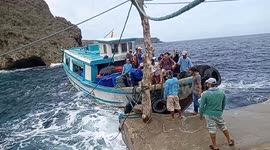 Locals have trouble disembarking from boat in choppy seas