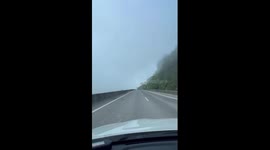 Car drives through mountain shrouded in mist in China