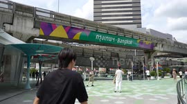 Tourist pose in front of new Bangkok sign on city bridge
