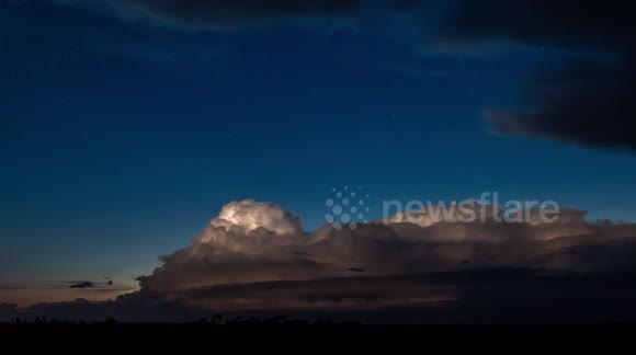 4k timelapse of a thunderstorm illuminated by the full moon. Stars in the background.