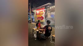 Diners enjoy barbecue dinner amid rippling floods in Thailand