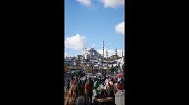 A crowd moves towards a Suleymaniye Mosque, highlighting its cultural heritage on a sunny day