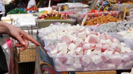 customer hand pointing Traditional Turkish Delights displaying for sale at market