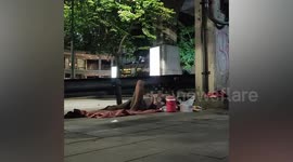 Good Samaritan gives snacks to sleeping homeless person in Bangkok