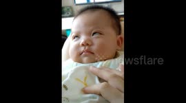 Baby rolling his eyes and smiling while he dreams