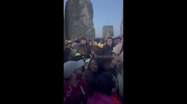 Security battling the crowd to remove a man climbing the stones at stone henge summer solstice 2024.