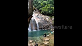 Man narrowly escapes serious injury after slipping from waterfall rocks in China
