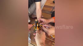 Friends show corkscrew hack to open wine bottle with candles