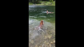 owner and spaniel wild swimming in a mountain water lake in Courchevel