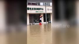 Man left soaked as he tries to walk through flood on two plastic stools