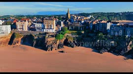 Flight across south beach Tenby showing the beach, properties and views of the towm