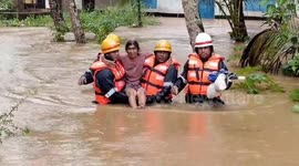 Rescuers carrying woman to safety during severe flooding in southern India