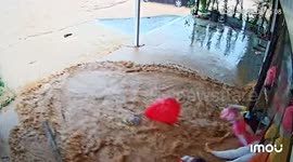 Flood bursts through glass shopfront sending inflatables into street