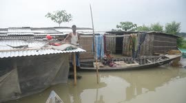 India: Residents stand on a boat near their flooded house in Morigaon