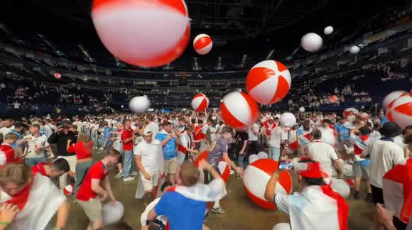 Football fans gather at The O2 Arena in London to watch the Euro Final on a big screen. The event offers a lively atmosphere with thousands of supporters cheering for England.