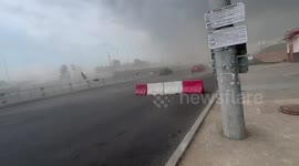 Strong winds in Minsk blow away road barrier and stir dust