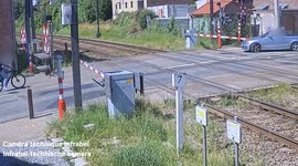 Cyclist almost flattened by train as he rides through crossing barriers