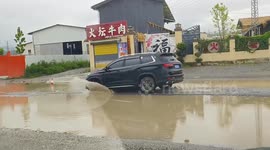 China: Vehicles Struggle on Muddy Road