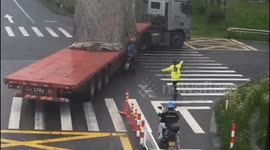 Heroic traffic cop shouts to stop truck about to run over scooter at busy Chinese intersection