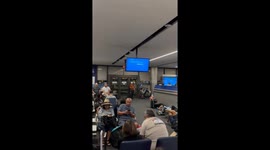 Passengers sit on floor at Los Angeles airport as worldwide IT outage causes travel chaos