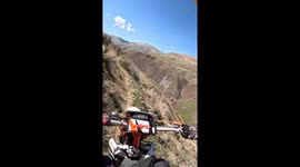 Group of iranian moto riders riding along an extremely tall and steep cliff drop off