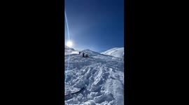 skier front flips over small canyon, lands it