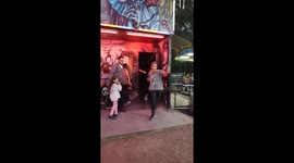 woman falls out of a scare house, merry go round in the background