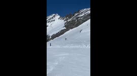 skier in the background of the clip tumbles down thorugh the shot