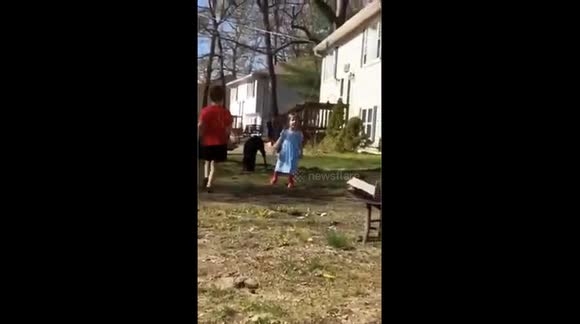 Kids playing in yard, girl dancing and singing kitty song, and little boy decides to try and break a piece of wood with his head, unsuccessfully