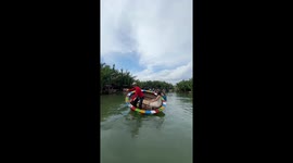 Girl tries spinning basket boat ride through river in Vietnam