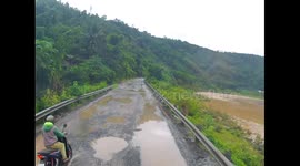 Motorbike rider falls into puddle on pothole-ridden road in Quảng Trị, Vietnam
