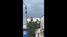 Photographer climbs electricity post for better vantage point