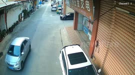 Scary moment young child falls out of car turning corner on busy street in China