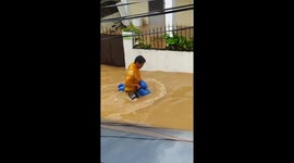 Resident floats through flooded road on rocking horse