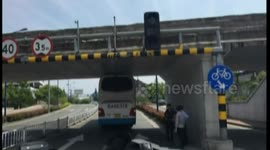 Coach gets stuck under a low bridge