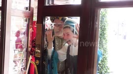 Horrible Histories Terrible Tudors stars Neal Foster and Emma Swan in character pose behind hotel window.