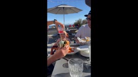 Tiny tot perfectly cheers her cup against dad's glass at a friends' gathering